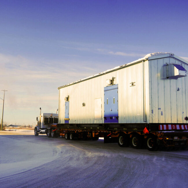 Revolution Crane Transport Truck moving a worksite trailer to site