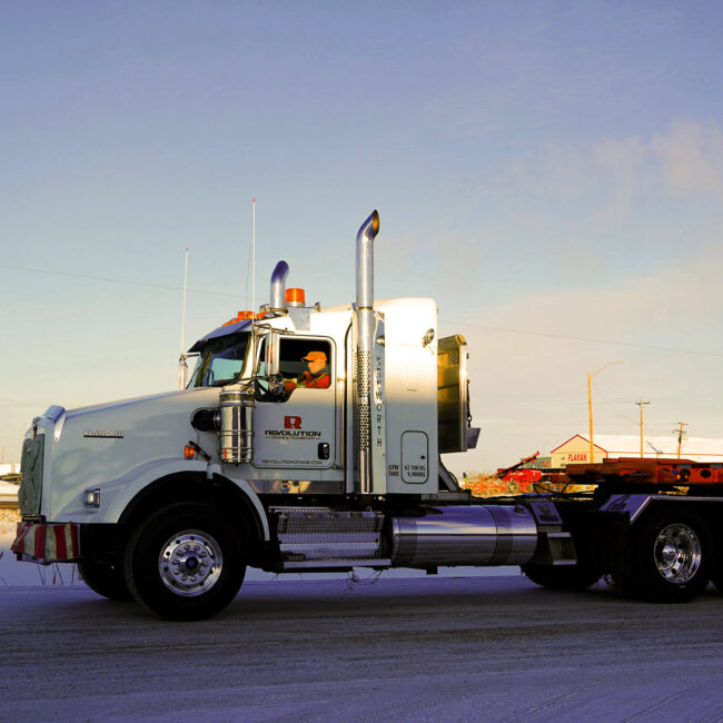 Revolution Crane Transport Truck moving a worksite trailer to site